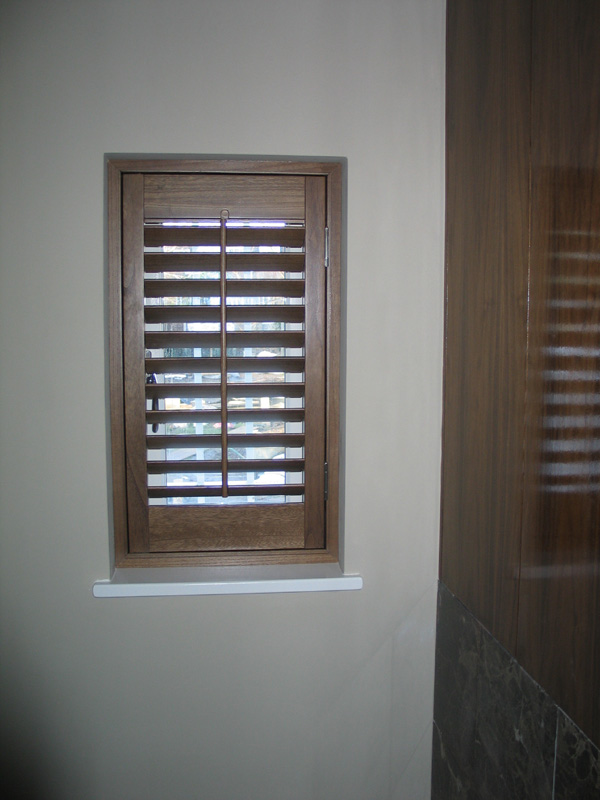 Plantation shutter in stained wood with 63mm louvres