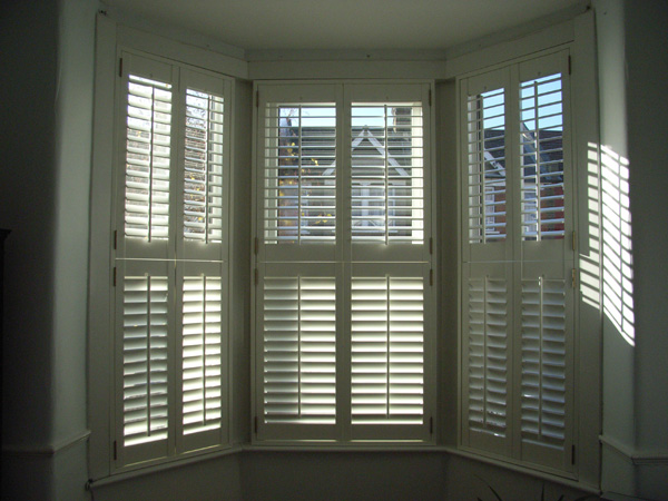 Tier-on-tier plantation shutters in wood with 63mm louvres