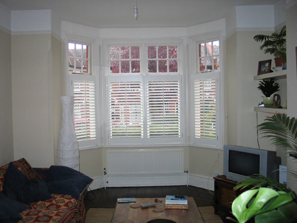 Plantation shutters in painted wood silk white with 63mm louvres