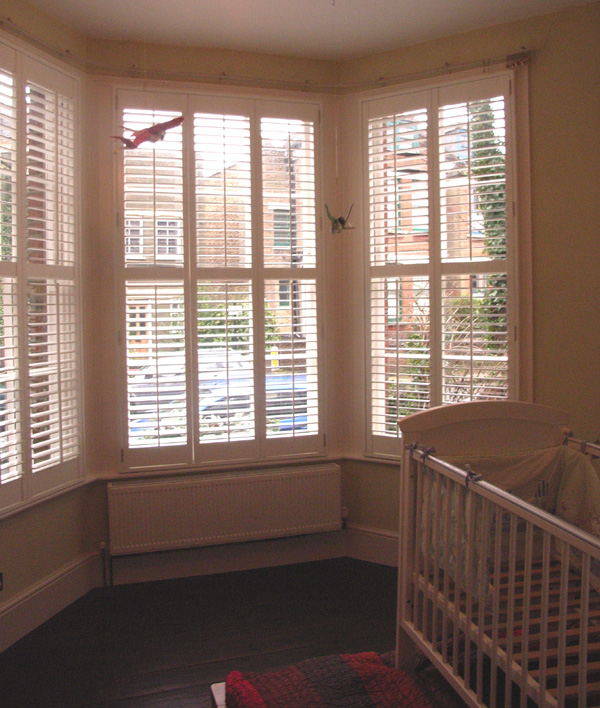 Painted wood plantation shutters in silk white with 63mm louvres - internal and external views