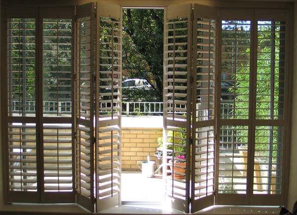 Full height Patio door shutters on a tracking system 63mm louvres, limed white stained wood