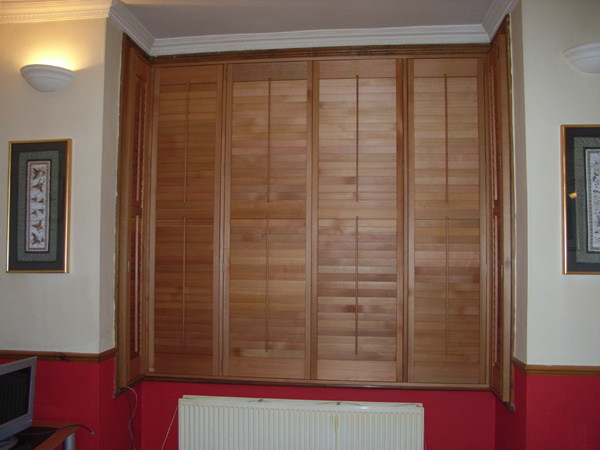 Plantation shutters in oiled cedar with 63mm louvres