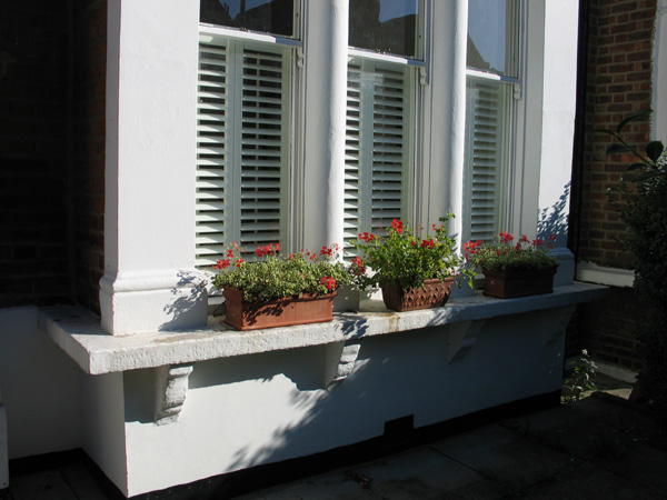 Internal and external views of cafe / half height plantation shutters in silk white with 47mm louvres