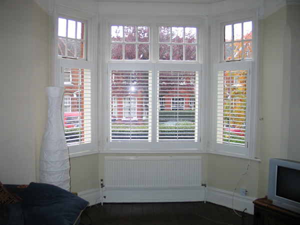 Plantation shutters in painted wood silk white with 63mm louvres