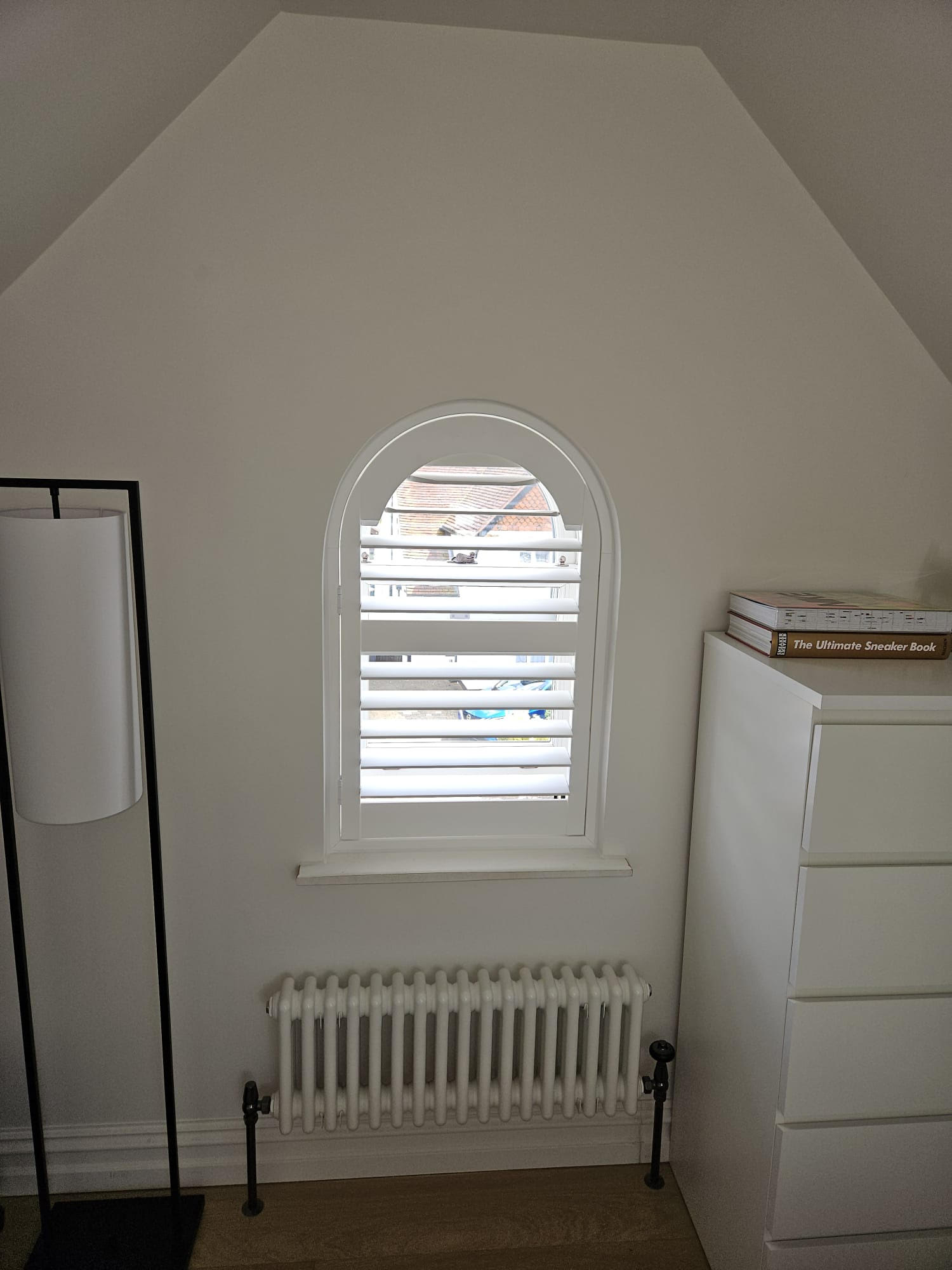 shaped shutter in white wood for arched window in East London