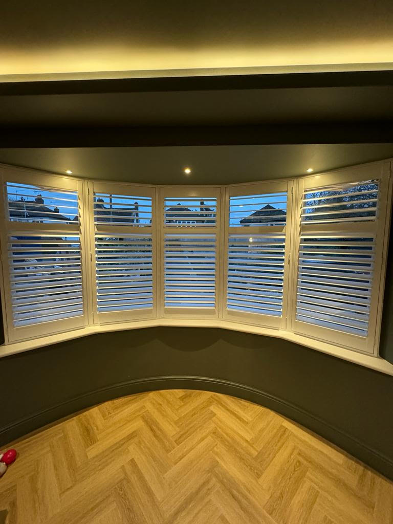 white painted wood plantation shutters for bay window in East London